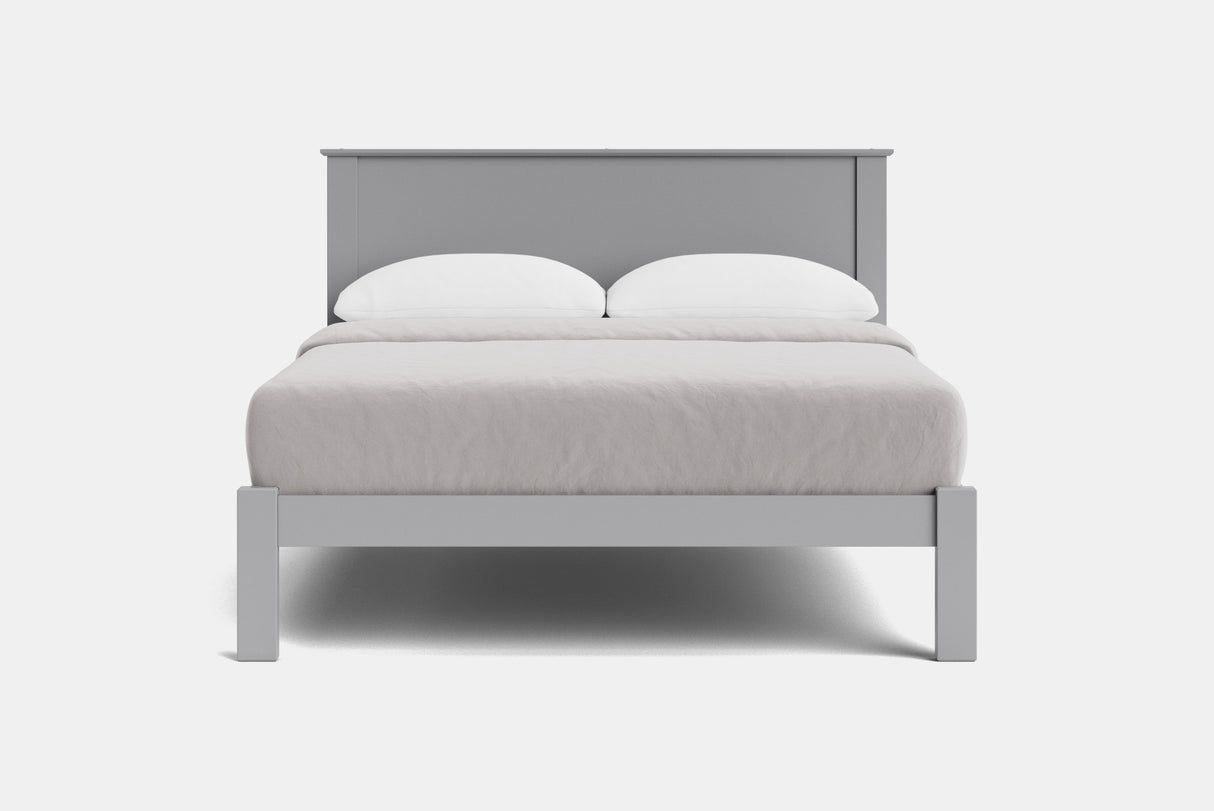 A modern light gray wooden bed frame with a low headboard and matching footboard, styled with white bedding and two white pillows against a plain white background.