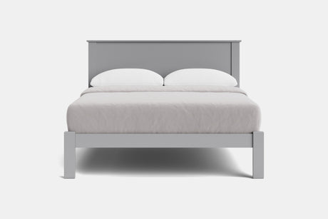 A modern light gray wooden bed frame with a low headboard and matching footboard, styled with white bedding and two white pillows against a plain white background.