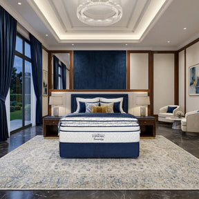 The Euphoric mattress in a luxurious bedroom setting with blue and white color scheme.